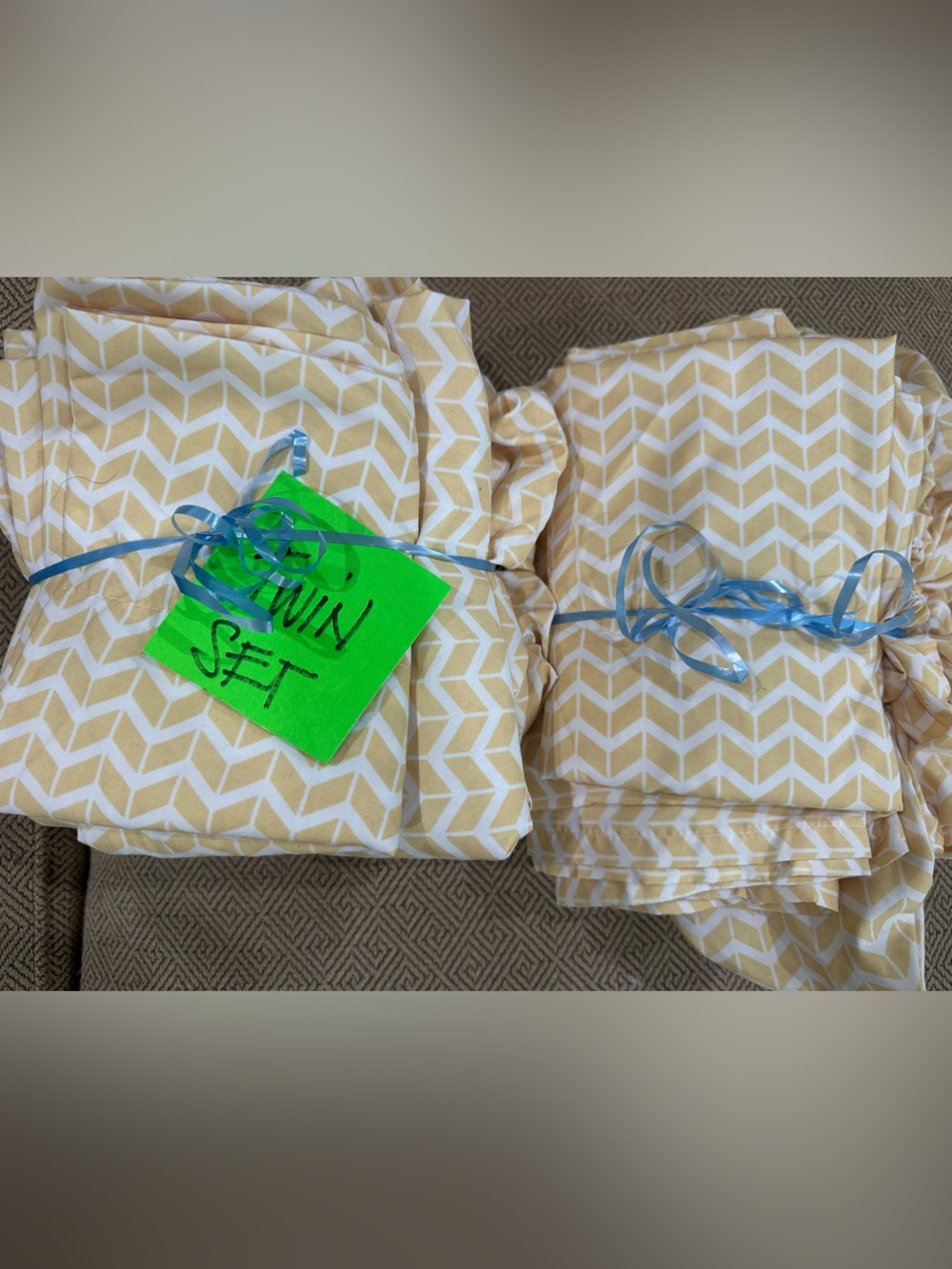 Two sets of twin sheets, light, goldish, color and white herringbone.
